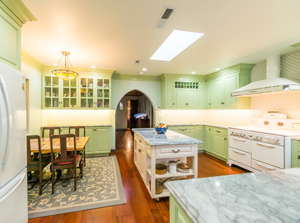 Стильный дизайн: п-образная кухня в классическом стиле с обеденным столом, зелеными фасадами и белой техникой - последний тренд