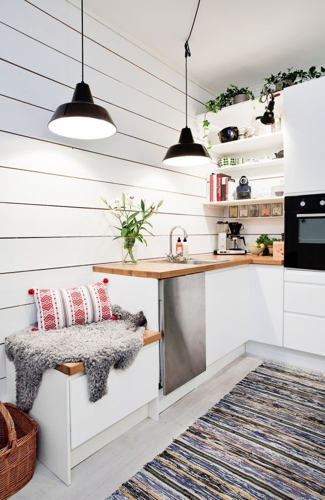 サンフランシスコにある小さな北欧スタイルのおしゃれなL型キッチン (ドロップインシンク、フラットパネル扉のキャビネット、白いキャビネット、白いキッチンパネル) の写真