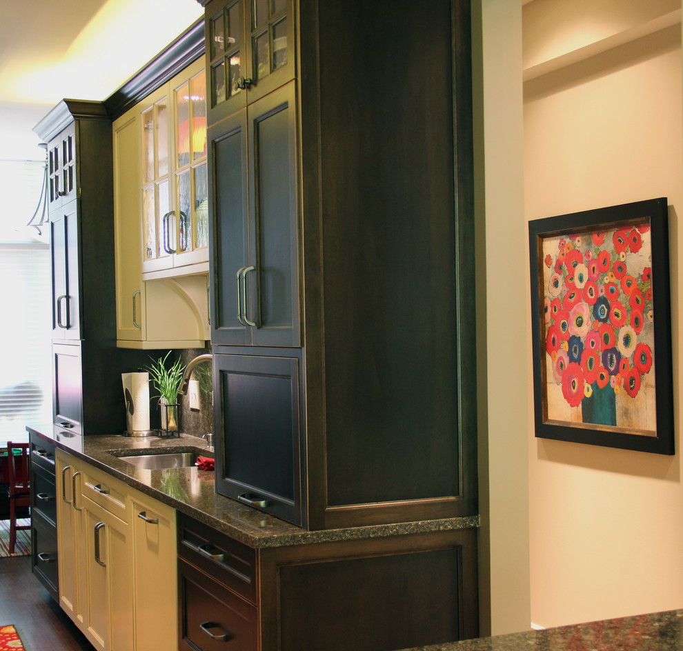 Klassisk inredning av ett litet kök, med en undermonterad diskho, luckor med infälld panel, vita skåp, granitbänkskiva, integrerade vitvaror, mellanmörkt trägolv och en halv köksö
