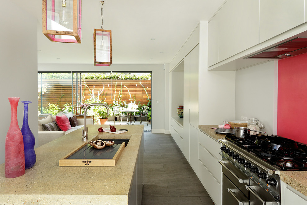 Inspiration for a contemporary kitchen in London with wood worktops, porcelain flooring, an island, a submerged sink, flat-panel cabinets, white cabinets, stainless steel appliances and pink splashback.