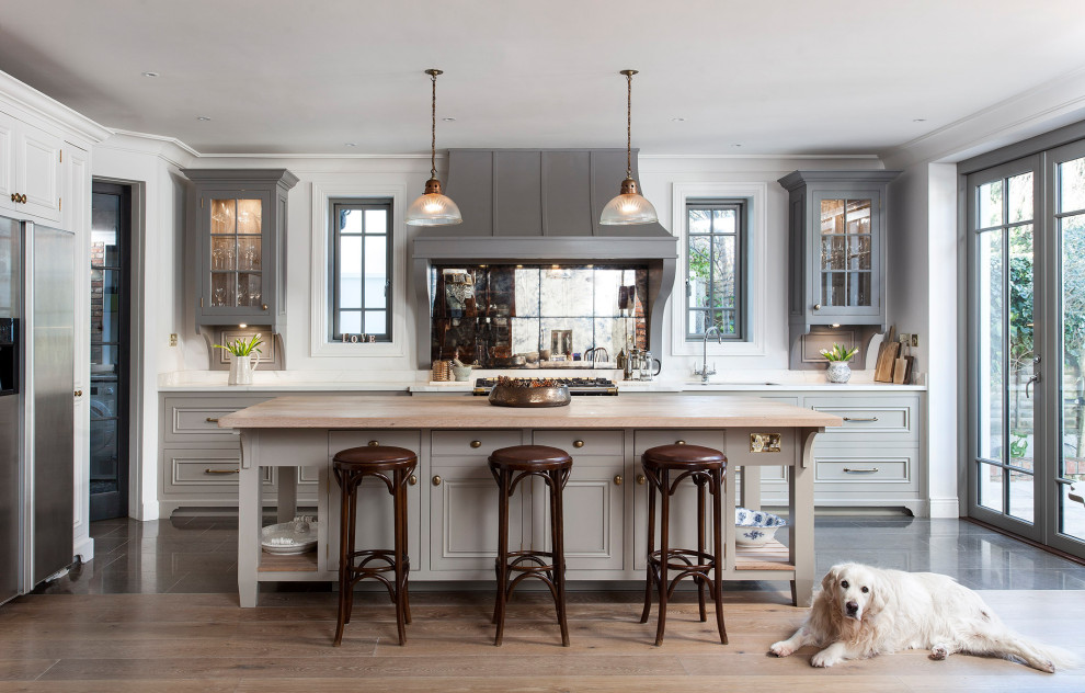 Example of a large classic l-shaped medium tone wood floor and beige floor kitchen design in Dublin with an undermount sink, beaded inset cabinets, gray cabinets, wood countertops, stainless steel appliances, an island and beige countertops