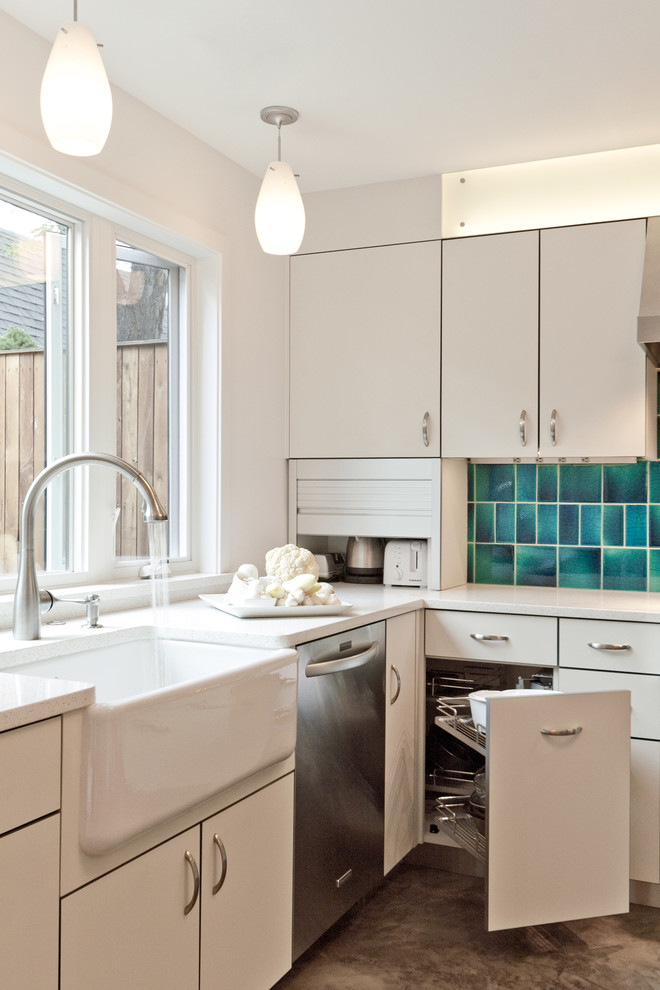 デンバーにあるコンテンポラリースタイルのおしゃれなL型キッチン (エプロンフロントシンク、フラットパネル扉のキャビネット、白いキャビネット、青いキッチンパネル) の写真