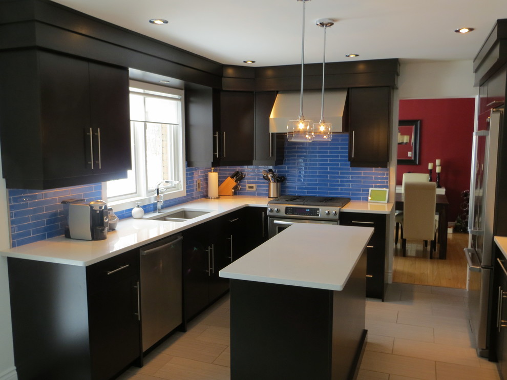 Mid-sized transitional enclosed kitchen photo in Other with an undermount sink, flat-panel cabinets, dark wood cabinets, quartz countertops, blue backsplash, glass tile backsplash, stainless steel appliances and an island