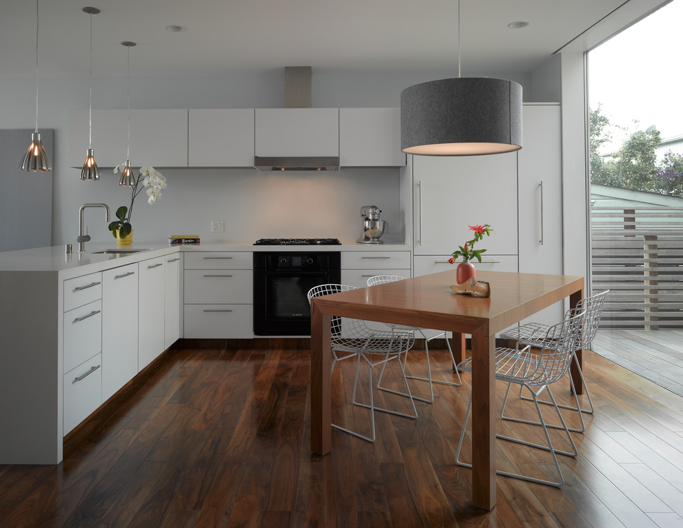 Inspiration for a modern l-shaped brown floor eat-in kitchen remodel in San Francisco with black appliances, an undermount sink, flat-panel cabinets, white cabinets and quartz countertops