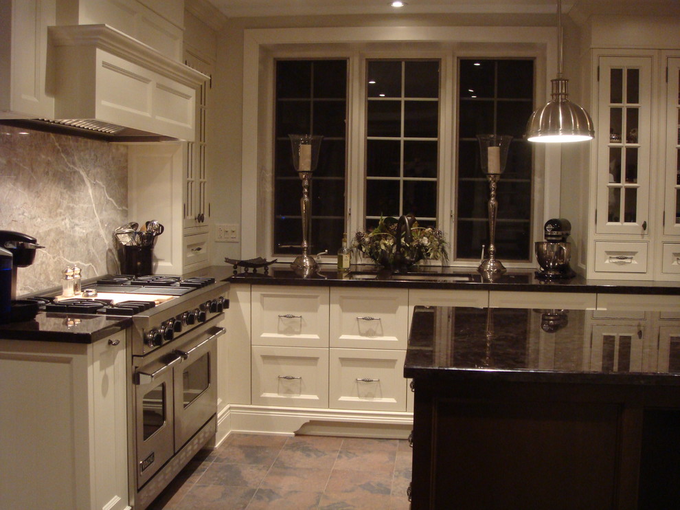 Bild på ett funkis kök, med luckor med glaspanel, rostfria vitvaror, vita skåp, stänkskydd i sten och granitbänkskiva