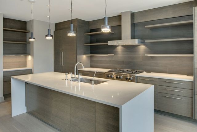 Mid-sized trendy l-shaped painted wood floor and gray floor open concept kitchen photo in Minneapolis with an undermount sink, flat-panel cabinets, light wood cabinets, quartz countertops, gray backsplash, wood backsplash, stainless steel appliances and an island