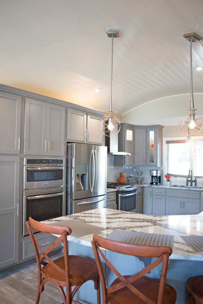 Inspiration för ett mellanstort amerikanskt flerfärgad flerfärgat kök, med en undermonterad diskho, luckor med infälld panel, grå skåp, bänkskiva i kvarts, vitt stänkskydd, stänkskydd i keramik, rostfria vitvaror, mellanmörkt trägolv, en halv köksö och grått golv