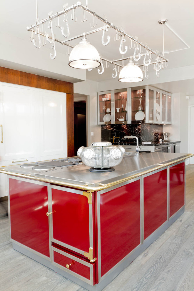 Cette image montre une cuisine design avec un placard à porte plane, un plan de travail en inox et des portes de placard rouges.