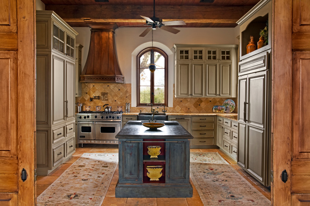 Inspiration for a large timeless u-shaped enclosed kitchen remodel in Houston with a farmhouse sink, raised-panel cabinets, green cabinets, granite countertops, beige backsplash, stone tile backsplash, paneled appliances and an island