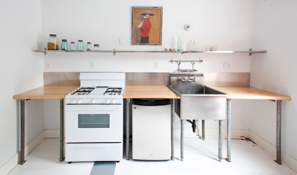 Industrial single-wall kitchen in New York with a belfast sink and white appliances.
