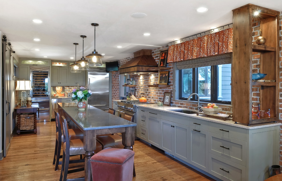 Moderne Küche ohne Insel mit Doppelwaschbecken, Schrankfronten mit vertiefter Füllung, grünen Schränken, Küchenrückwand in Rot, Küchengeräten aus Edelstahl und braunem Holzboden in Charleston