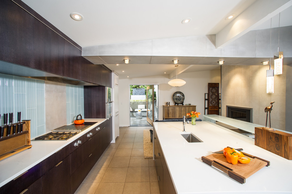 Esempio di una cucina parallela minimal con lavello sottopiano, ante lisce, ante in legno bruno e paraspruzzi blu