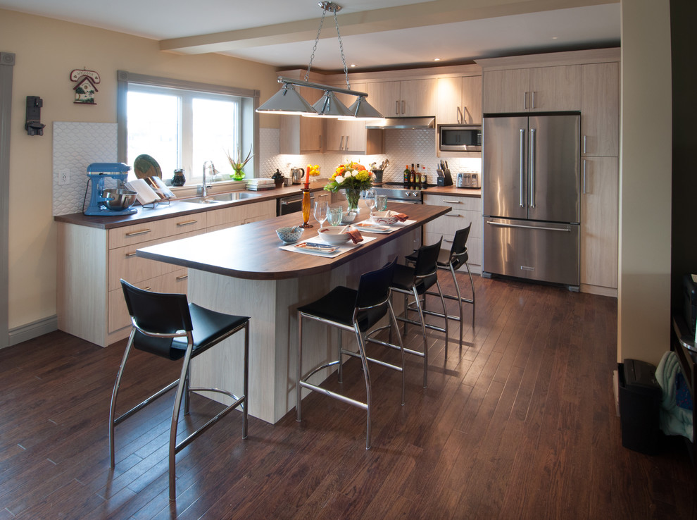 Mid-sized country l-shaped dark wood floor kitchen photo in Toronto with a double-bowl sink, flat-panel cabinets, light wood cabinets, wood countertops, white backsplash, porcelain backsplash, stainless steel appliances and an island