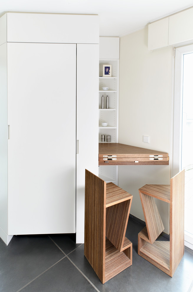 Cette image montre une cuisine américaine minimaliste en bois foncé avec un placard à porte plane.