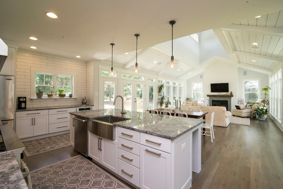 Exempel på ett lantligt kök, med en rustik diskho, skåp i shakerstil, vita skåp, granitbänkskiva, vitt stänkskydd, stänkskydd i keramik, rostfria vitvaror, mellanmörkt trägolv och en köksö