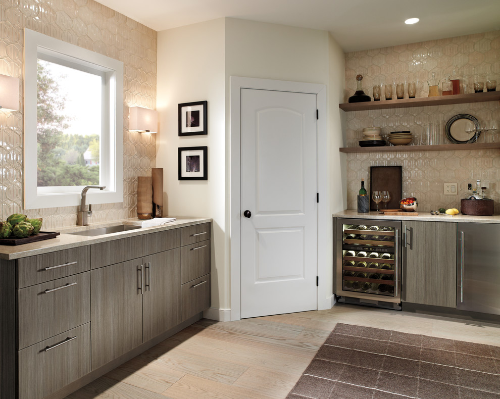 Medium sized traditional kitchen in New York with a submerged sink, flat-panel cabinets, grey cabinets, beige splashback, ceramic splashback and light hardwood flooring.
