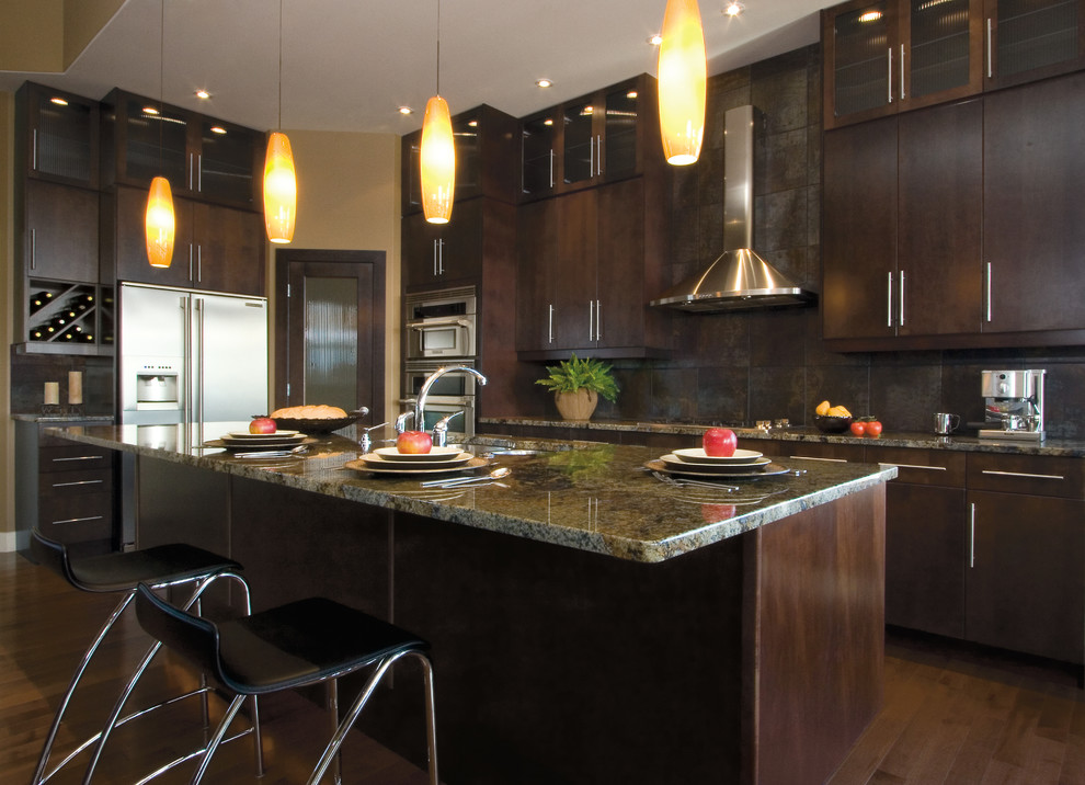 Medium sized traditional u-shaped kitchen/diner in New York with flat-panel cabinets, dark wood cabinets, granite worktops, stainless steel appliances, medium hardwood flooring, an island, a double-bowl sink, brown splashback and stone tiled splashback.