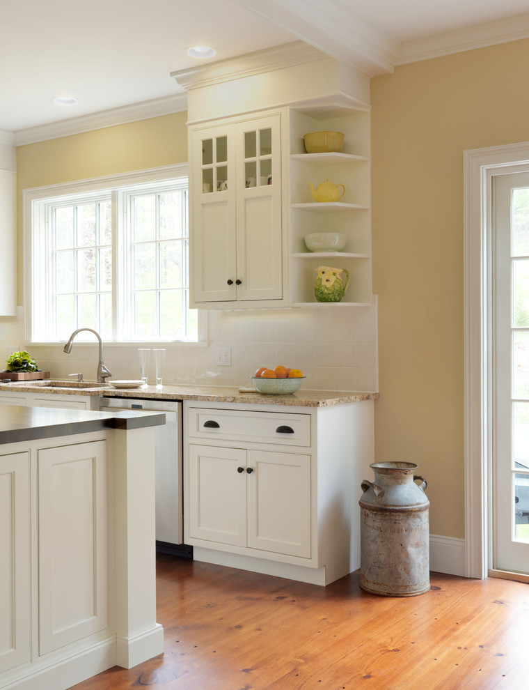 Exempel på ett lantligt kök, med en dubbel diskho, skåp i shakerstil, vita skåp, granitbänkskiva, vitt stänkskydd, stänkskydd i tunnelbanekakel, rostfria vitvaror, mellanmörkt trägolv och en köksö