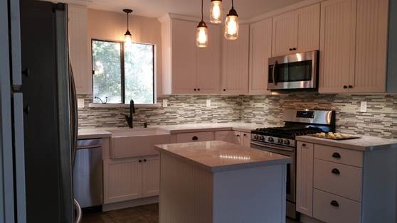 Idéer för att renovera ett avskilt, mellanstort lantligt u-kök, med en rustik diskho, luckor med infälld panel, vita skåp, granitbänkskiva, grått stänkskydd, stänkskydd i stickkakel, rostfria vitvaror och en köksö
