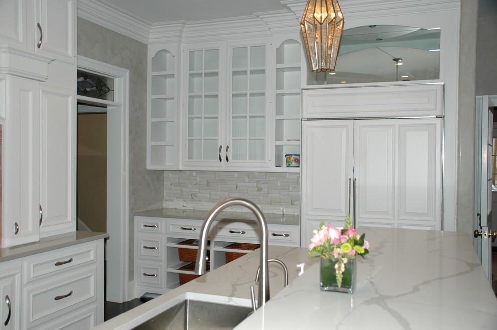 Example of a large transitional l-shaped dark wood floor eat-in kitchen design in Philadelphia with an undermount sink, raised-panel cabinets, white cabinets, quartzite countertops, gray backsplash, stone tile backsplash, paneled appliances and an island
