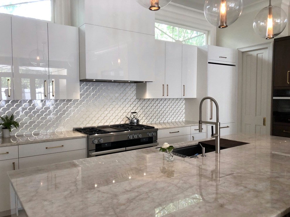 Medium sized contemporary l-shaped open plan kitchen in New Orleans with an integrated sink, flat-panel cabinets, white cabinets, quartz worktops, metallic splashback, marble splashback, integrated appliances, porcelain flooring, an island and grey floors.