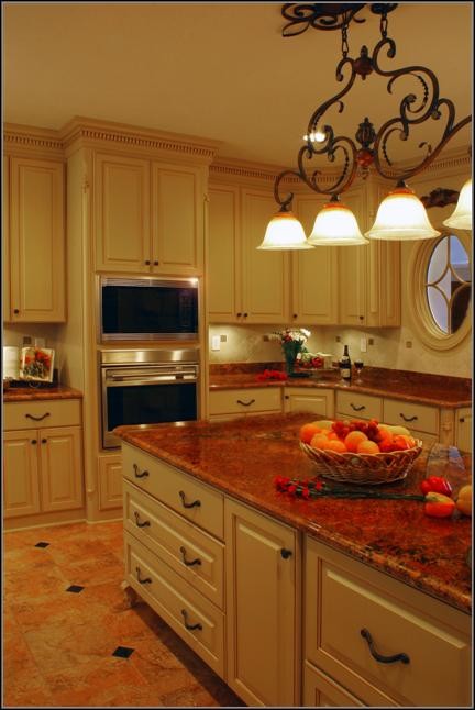 Foto på ett stort vintage kök, med en nedsänkt diskho, luckor med lamellpanel, vita skåp, granitbänkskiva, stänkskydd i sten, rostfria vitvaror, klinkergolv i terrakotta och en köksö