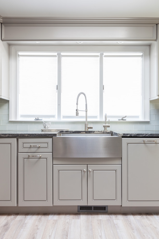 Cette image montre une cuisine design avec un placard à porte shaker et des portes de placard grises.