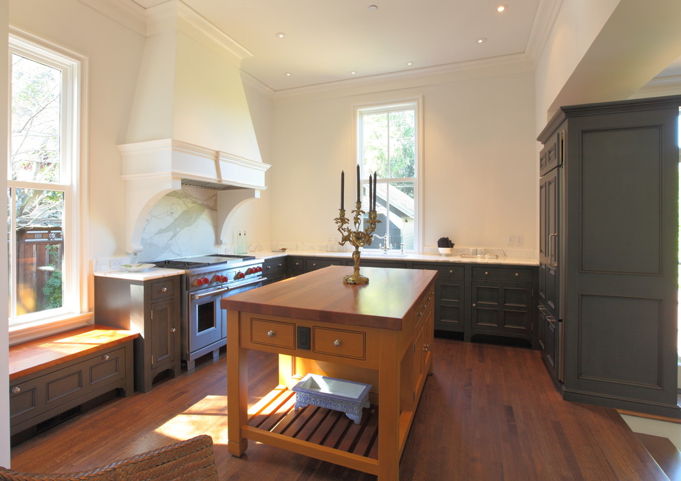 Пример оригинального дизайна: кухня в классическом стиле с фасадами с утопленной филенкой, техникой под мебельный фасад и деревянной столешницей