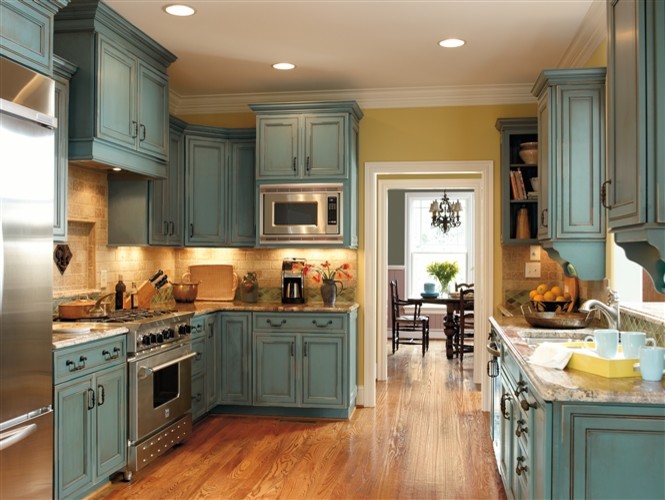 Exempel på ett avskilt lantligt l-kök, med luckor med infälld panel, blå skåp, granitbänkskiva, beige stänkskydd, stänkskydd i keramik, rostfria vitvaror och mellanmörkt trägolv
