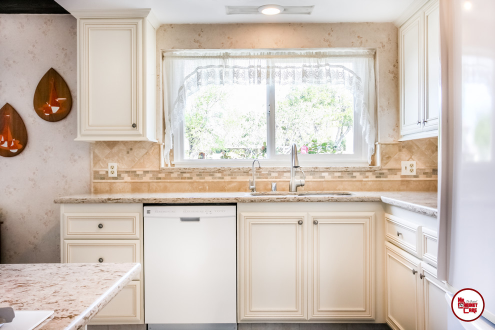 Bild på ett avskilt, mellanstort vintage l-kök, med en undermonterad diskho, luckor med upphöjd panel, vita skåp, bänkskiva i kvarts, flerfärgad stänkskydd, stänkskydd i stenkakel, vita vitvaror, klinkergolv i porslin och en köksö