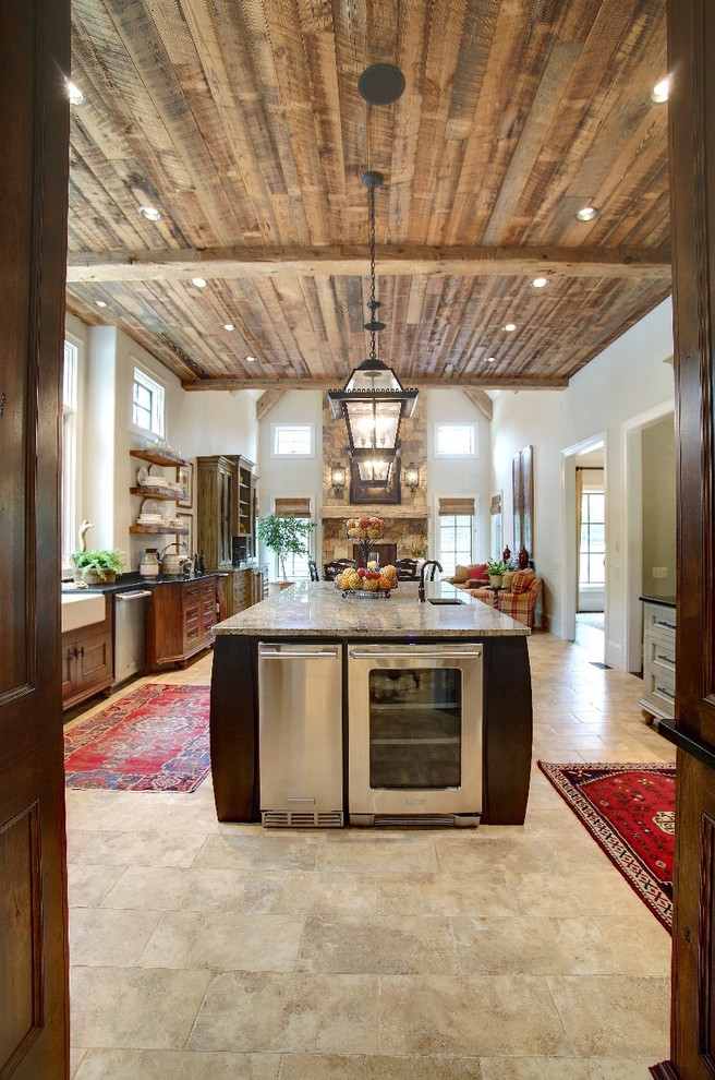 Eat-in kitchen - rustic eat-in kitchen idea in Other with stainless steel appliances and an island