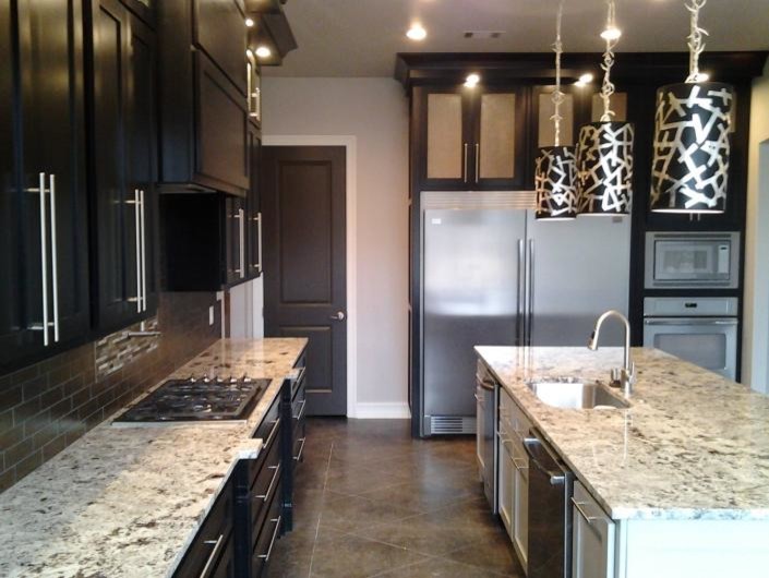Foto på ett stort funkis kök, med en undermonterad diskho, luckor med upphöjd panel, svarta skåp, granitbänkskiva, grått stänkskydd, stänkskydd i keramik, rostfria vitvaror, skiffergolv och en köksö