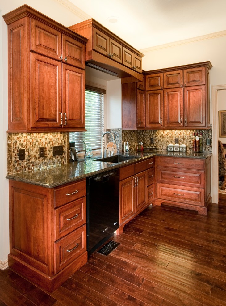 Diseño de cocina comedor clásica de tamaño medio sin isla con armarios con paneles con relieve, puertas de armario de madera oscura y encimera de granito