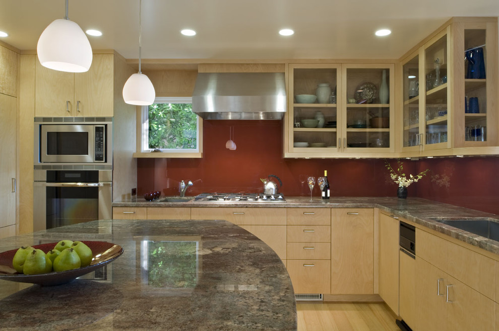 Trendy kitchen photo in San Francisco with glass-front cabinets, stainless steel appliances, an undermount sink, light wood cabinets, granite countertops, red backsplash and glass sheet backsplash
