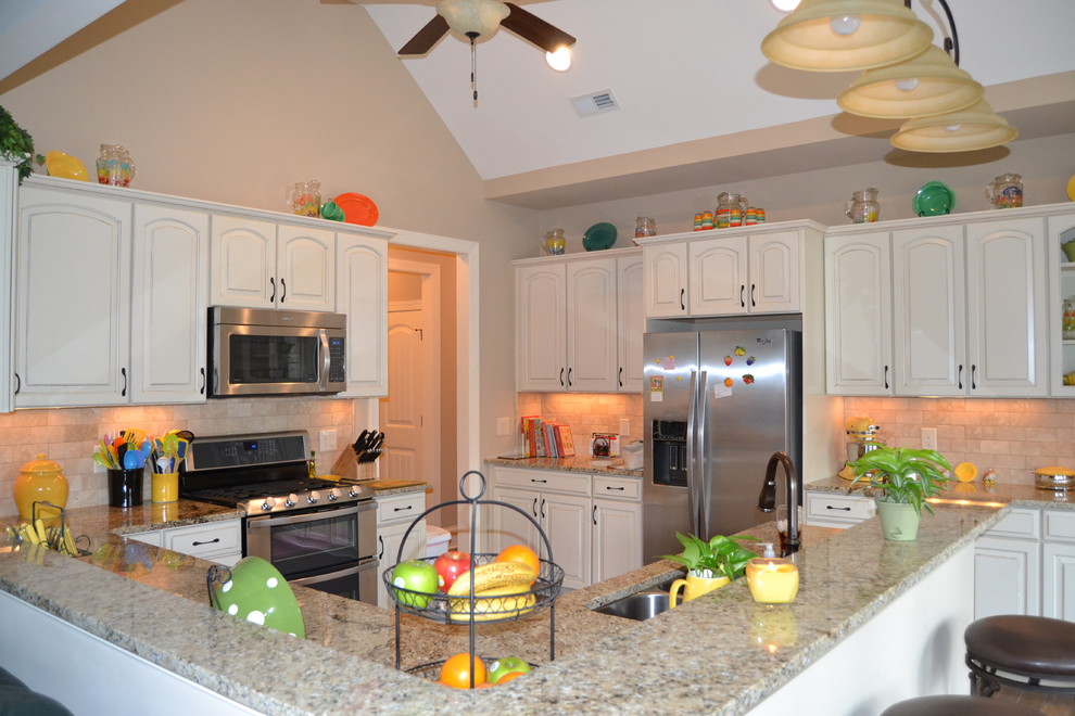 Exempel på ett rustikt kök med öppen planlösning, med granitbänkskiva, rostfria vitvaror, beige skåp och beige stänkskydd