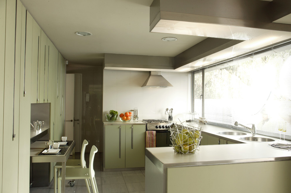 Moderne Küche mit Laminat-Arbeitsplatte, flächenbündigen Schrankfronten und grünen Schränken in Sonstige