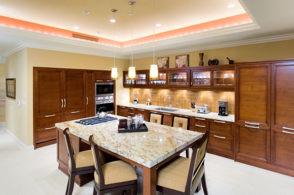 Example of an island style l-shaped limestone floor open concept kitchen design in Hawaii with a single-bowl sink, shaker cabinets, medium tone wood cabinets, granite countertops, yellow backsplash, glass tile backsplash, paneled appliances and an island