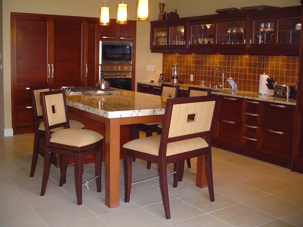 Island style l-shaped limestone floor open concept kitchen photo in Hawaii with a single-bowl sink, shaker cabinets, medium tone wood cabinets, granite countertops, brown backsplash, glass tile backsplash, paneled appliances and an island