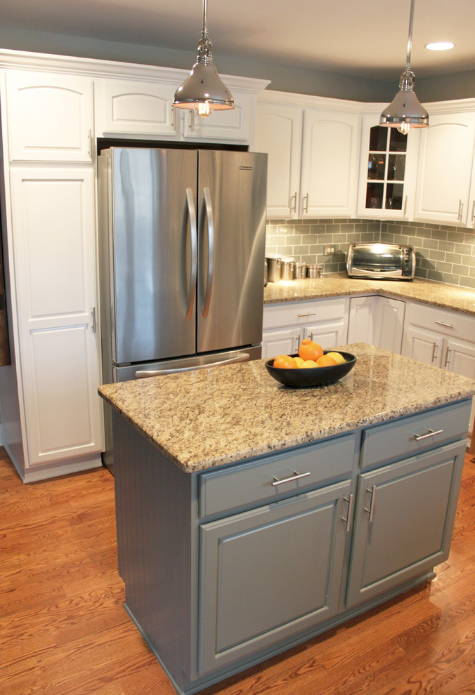 Example of a mid-sized transitional u-shaped medium tone wood floor eat-in kitchen design in Chicago with an undermount sink, recessed-panel cabinets, white cabinets, granite countertops, stainless steel appliances and an island