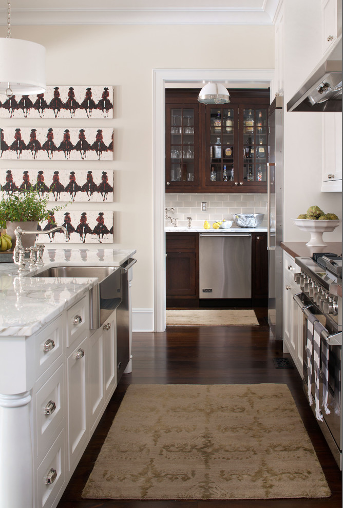 Ejemplo de cocina clásica con armarios con paneles empotrados, electrodomésticos de acero inoxidable, fregadero sobremueble y puertas de armario blancas