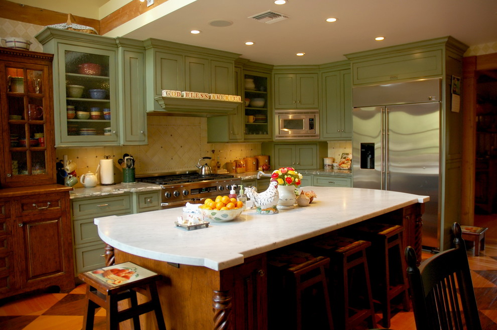 This is an example of a farmhouse kitchen in Los Angeles with green cabinets and stainless steel appliances.