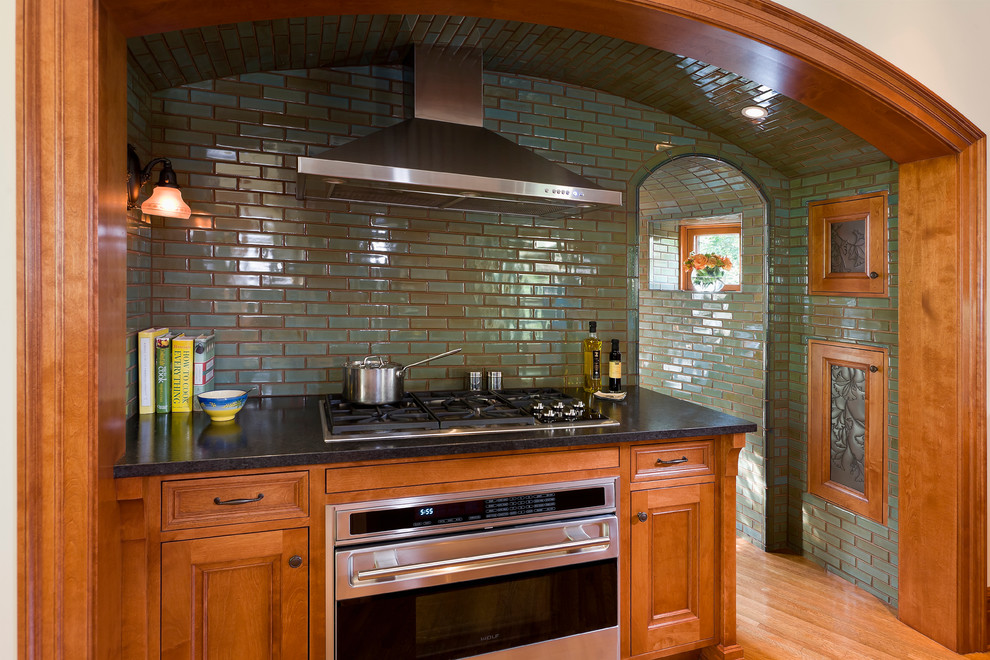 Mid-sized elegant l-shaped light wood floor eat-in kitchen photo in Minneapolis with recessed-panel cabinets, medium tone wood cabinets, granite countertops, subway tile backsplash, stainless steel appliances and an island