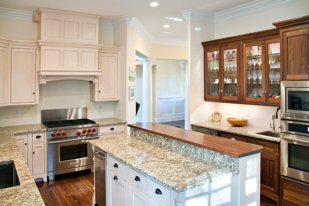 Inspiration for a mid-sized timeless u-shaped medium tone wood floor enclosed kitchen remodel in Charleston with an undermount sink, beige cabinets, granite countertops and stainless steel appliances