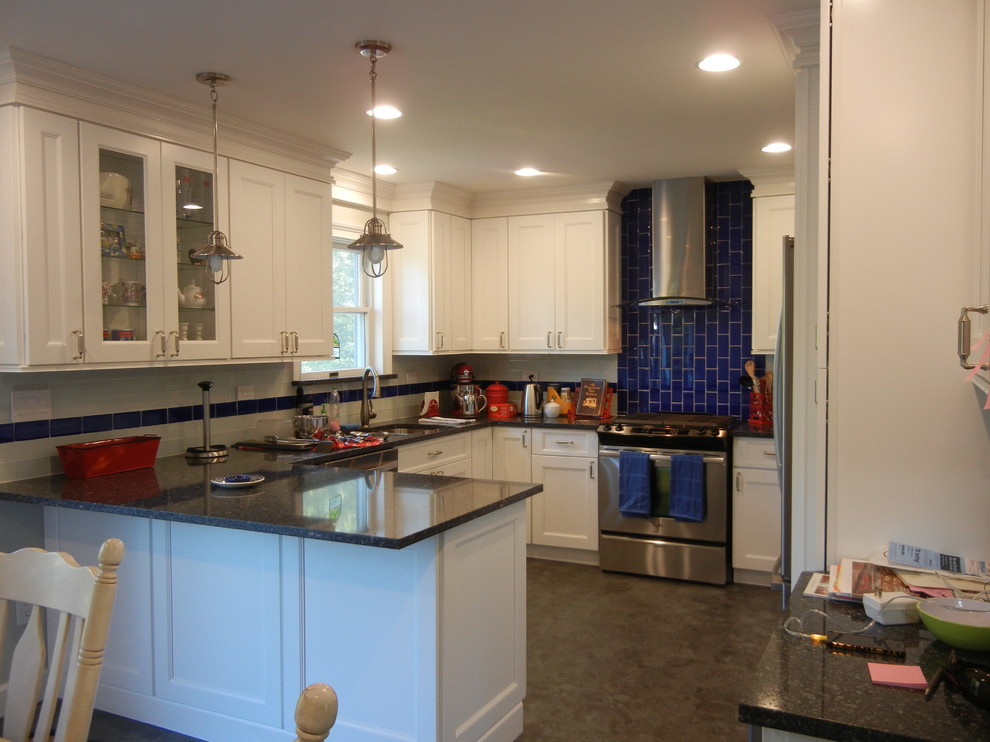 Mid-sized transitional u-shaped concrete floor and gray floor eat-in kitchen photo in New York with a double-bowl sink, recessed-panel cabinets, white cabinets, granite countertops, blue backsplash, subway tile backsplash, stainless steel appliances and a peninsula