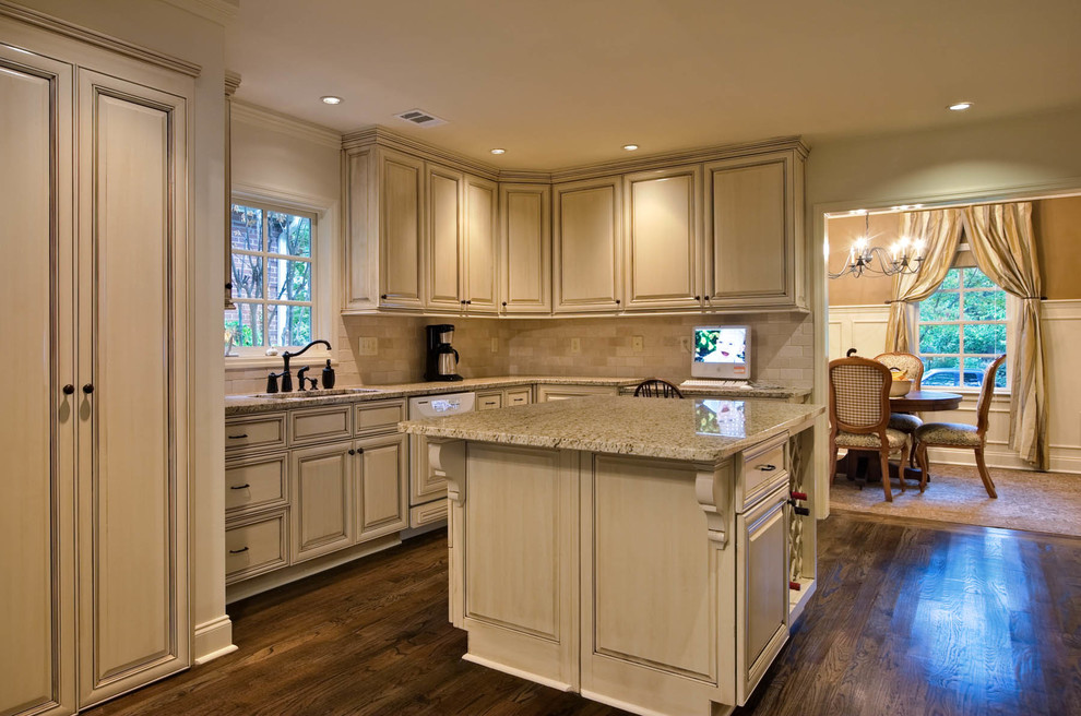 Inspiration for a large timeless dark wood floor and brown floor enclosed kitchen remodel in Los Angeles with an undermount sink, raised-panel cabinets, light wood cabinets, granite countertops, beige backsplash, stone tile backsplash, paneled appliances, an island and gray countertops