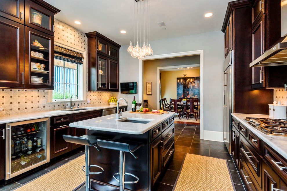 Mid-sized tuscan u-shaped slate floor and gray floor enclosed kitchen photo in DC Metro with an undermount sink, raised-panel cabinets, dark wood cabinets, marble countertops, white backsplash, marble backsplash, stainless steel appliances and an island