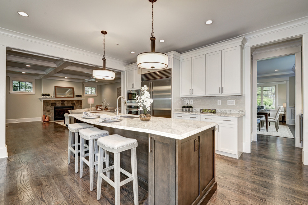 Inspiration for a large timeless l-shaped medium tone wood floor open concept kitchen remodel in DC Metro with an undermount sink, shaker cabinets, white cabinets, marble countertops, yellow backsplash, subway tile backsplash, stainless steel appliances and an island