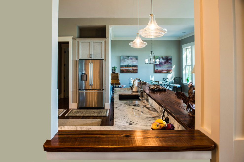 Kitchen - mid-sized transitional medium tone wood floor kitchen idea in Charleston with an undermount sink, gray cabinets, granite countertops, beige backsplash and stainless steel appliances