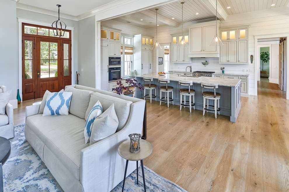 Inspiration for a large coastal kitchen in Charleston with a built-in sink, white splashback, wood splashback, stainless steel appliances, light hardwood flooring, an island, brown floors and grey worktops.