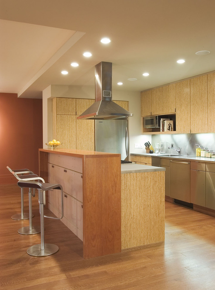 Diseño de cocina contemporánea con electrodomésticos de acero inoxidable y encimera de madera